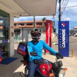 Entregador da Drogaria Canindé em frente à loja, pronto para realizar entregas. Atendimento rápido para quem busca farmácia 24 horas entrega a domicílio natal rn